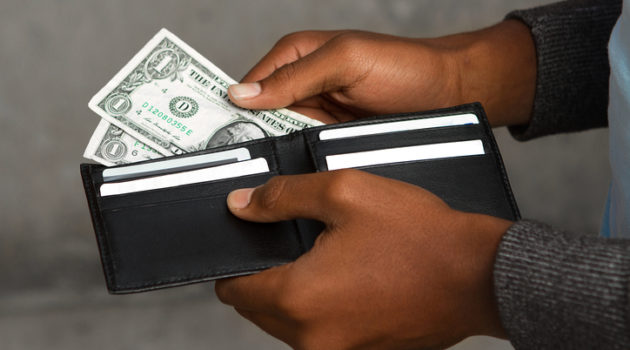African American man pulling money out wallet