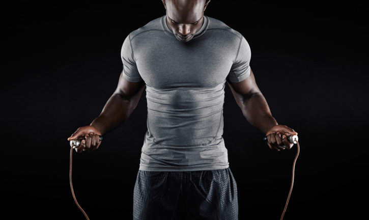 Muscular African american man jumping rope