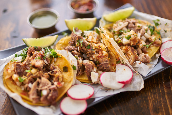 three street tacos in yellow corn tortilla with different meats, also has radishes