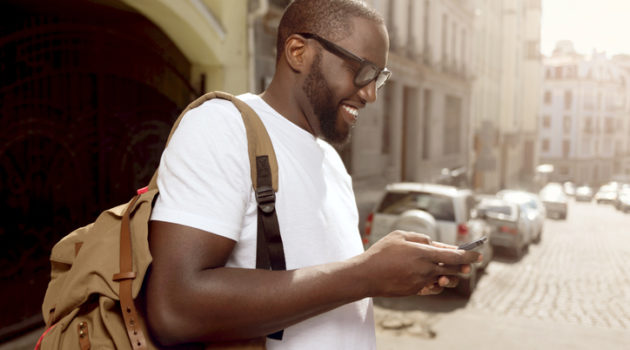 African American man smiling using cell phone