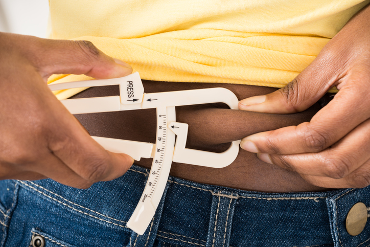 African American woman measuring fat with caliper