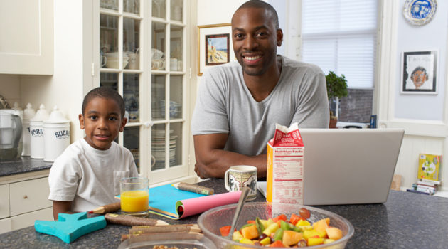 African American father and son breakfast in kitchen