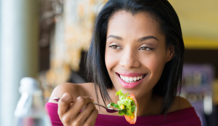African American woman eating salad