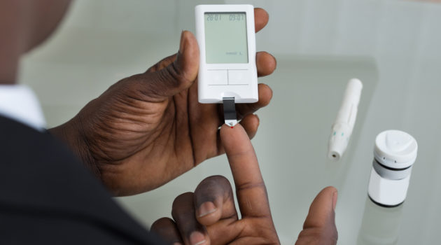 African American man testing blood sugar diabetes