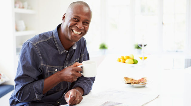 African American man eating breakfast with coffee