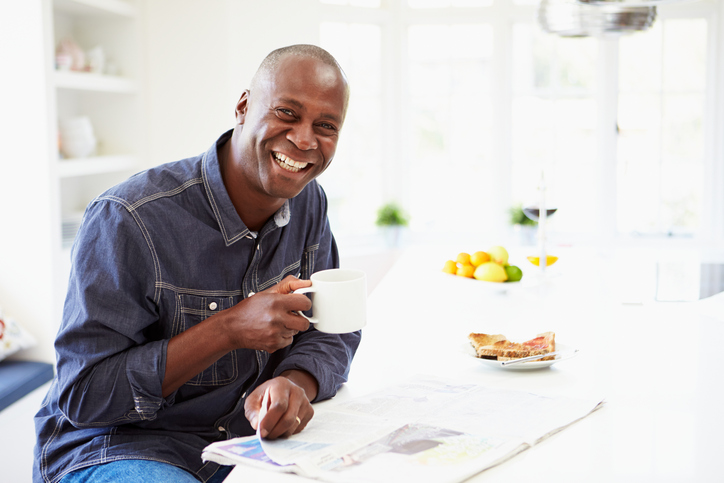 African American man eating breakfast with coffee