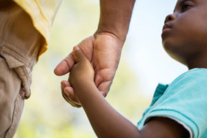 African American father and son holding hands