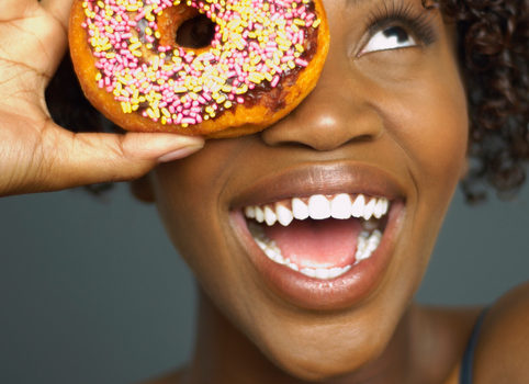 African American woman smiling with donut