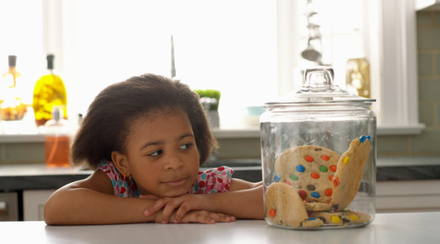 African American girl looking at cookie jar