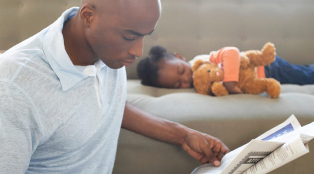 African American man father reading daughter sleeping