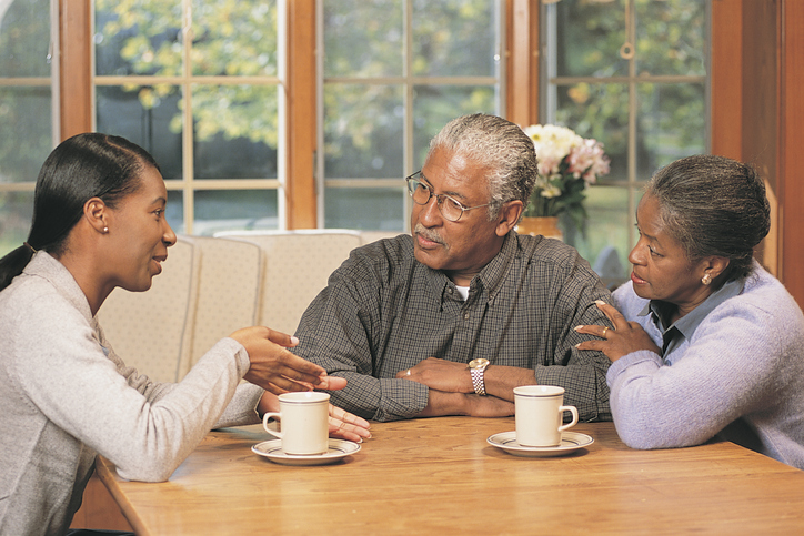 African American family talking at kitchen table