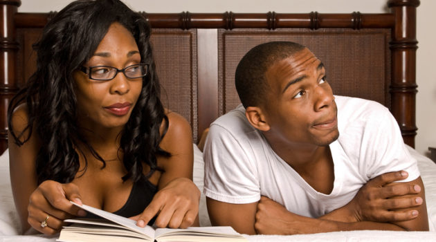 African American couple in bed reading
