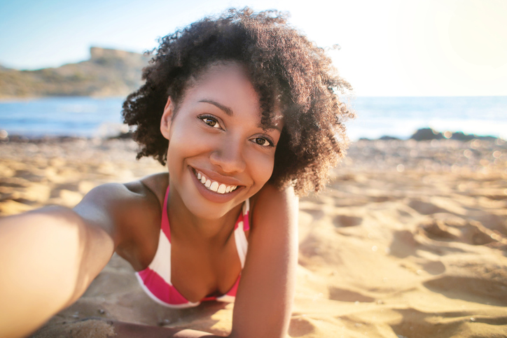 African American woman taking selfie on the beach