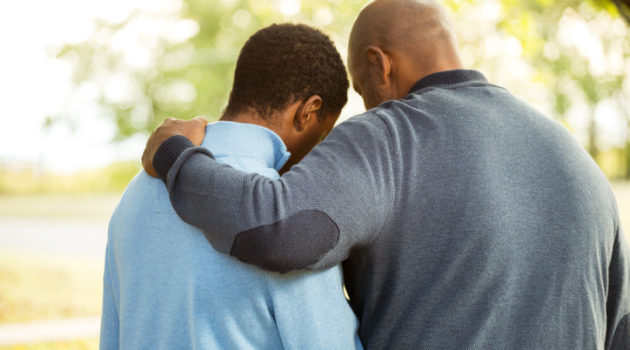 African American father and son hugging