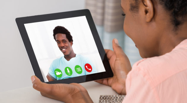 African American woman talking to man via tablet video