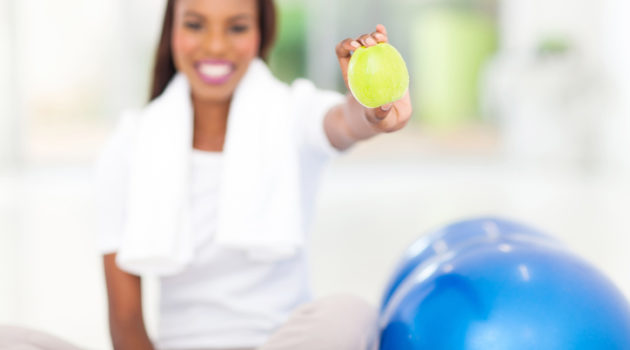 African American woman with apple and exercise ball