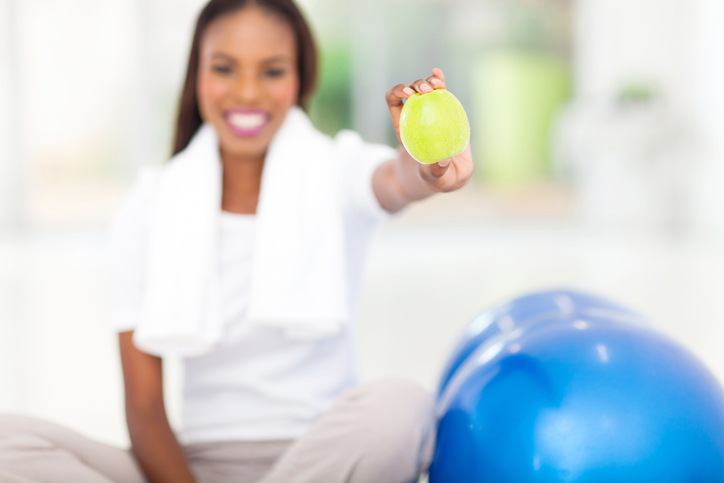 African American woman with apple and exercise ball
