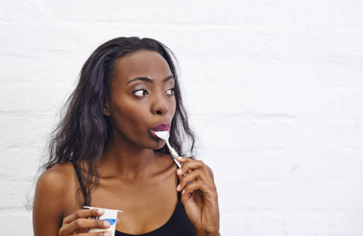 African american woman eating yogurt