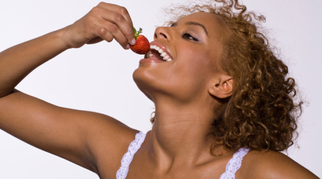 African American woman eating strawberry