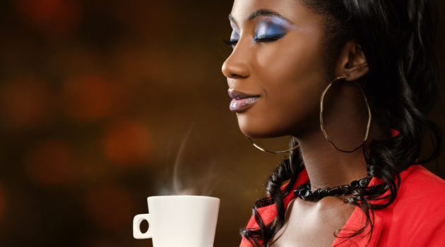 African American woman smelling coffee