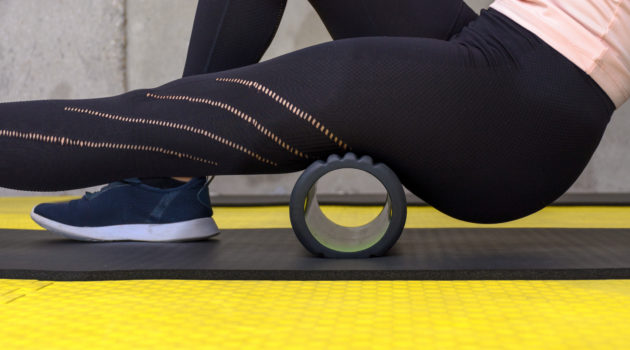 Close up view of woman exercising with foam roller