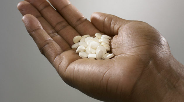 Person with a handful of pills