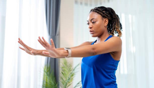 a woman in a blue shirt stretching her arms